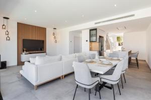 a living room with a white couch and a table and chairs at Chalet con Piscina en San Javier in San Javier