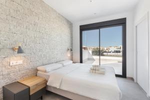 a bedroom with two beds and a brick wall at Chalet con Piscina en San Javier in San Javier +30 photos