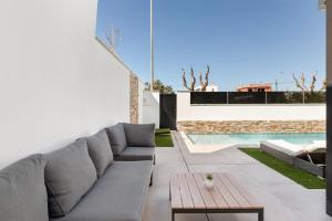 a patio with a couch and a table and a pool at Chalet con Piscina en San Javier in San Javier