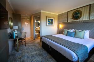 a hotel room with a large bed and a desk at The Gailes Hotel & Spa in Irvine +101 photos