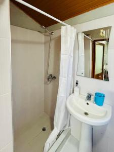 a white bathroom with a sink and a shower at Siera Home in Berat +12 photos
