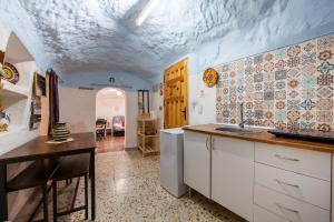 a kitchen with a sink and a table in a room at Cueva in Almería +18 photos