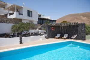 a villa with a swimming pool and a house at Finca La Calerita C in Yaiza