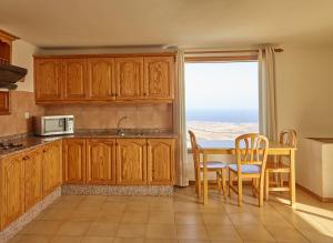 a kitchen with wooden cabinets and a table with chairs at Finca La Calerita C in Yaiza +16 photos