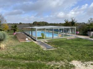 a large glass house with a swimming pool at Gite Le Paradis in Pern