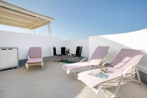 a room with two chairs and a table and a table and chairs at Casa del Sol Rosa in Corralejo
