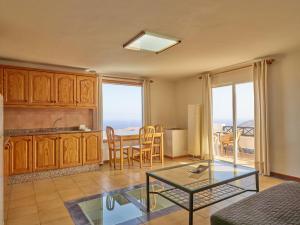 a living room with a glass table and a kitchen at Finca La Calerita C in Yaiza