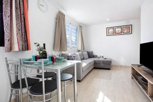a living room with a table and a couch at Casa del Sol Rosa in Corralejo