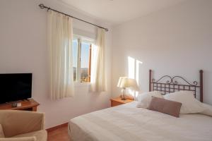 a bedroom with a bed and a tv and a window at El Balcón de la Sierra in Seville +14 photos