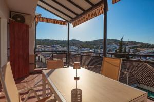 a table and chairs on a balcony with a view at El Balcón de la Sierra in Seville