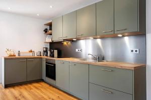 a kitchen with gray cabinets and a wooden floor at Ferienwohnung Götz in Roßhaupten