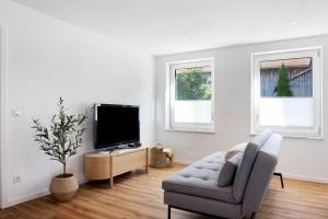 a living room with a chair and a television at Ferienwohnung Götz in Roßhaupten