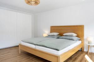a bedroom with a large bed with a wooden headboard at Ferienwohnung Götz in Roßhaupten