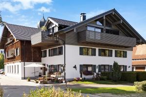 a large white house with a black roof at Ferienwohnung Götz in Roßhaupten