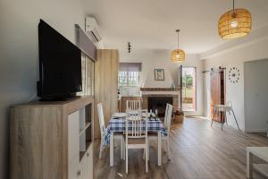 a kitchen and dining room with a table and a tv at Villa Manolita in Carmona