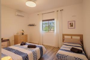 a bedroom with two beds and a window at Villa Manolita in Carmona +28 photos
