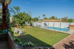 a yard with two chairs and a swimming pool at Villa Manolita in Carmona
