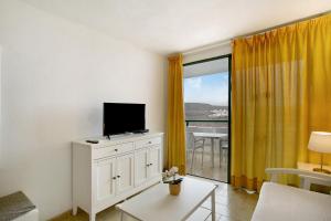 a living room with a tv on a white dresser at Casa Puerto Rico in Mogán