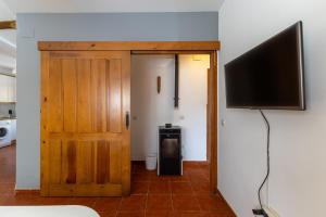a room with a door and a flat screen tv at De los Maestros in El Arenal