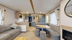 a caravan living room with a couch and a table at Unity Seven Lakes in Crowle