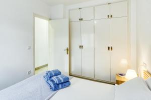 a bedroom with white cabinets and blue towels on a bed at Lago Sant Mauricio in Empuriabrava