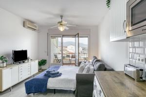 a white living room with a couch and a tv at Lago Sant Mauricio in Empuriabrava