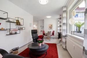 a living room with white walls and a red rug at Ferienwohnung Steffi in Laichingen