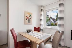 a dining room with a wooden table and red chairs at Ferienwohnung Steffi in Laichingen