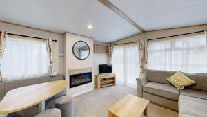 a living room with a couch and a table at Unity Seven Lakes in Crowle