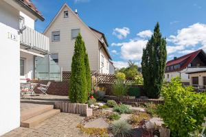 a garden in front of a house with trees at Ferienwohnung Steffi in Laichingen