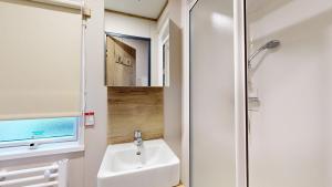 a small bathroom with a sink and a shower at Unity Seven Lakes in Crowle