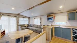 a kitchen and living room with a couch and a table at Unity Seven Lakes in Crowle +43 photos