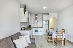 a living room with a couch and a table and a kitchen at Lago Sant Mauricio in Empuriabrava