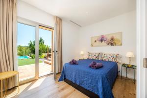 a bedroom with a bed with purple pillows on it at Finca Son Montserrat in Llucmajor +31 photos