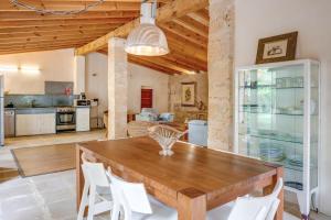 a kitchen and dining room with a wooden table and chairs at Possessio Sa Barrala Gallinero in Campos
