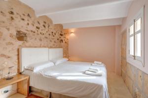a bedroom with a white bed and a window at Possessio Sa Barrala Gallinero in Campos +29 photos