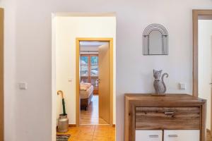 a hallway with a door leading into a room with a cat statue on a table at Fewo Maria Grasegger in Grainau +26 photos