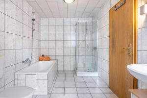 a bathroom with a tub and a shower and a sink at Monteurwohnung Schulze in Bad Bodenteich +11 photos