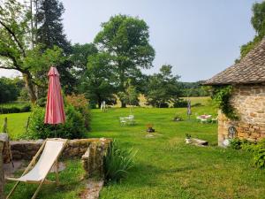 an umbrella and a chair in a yard at Maison de Vacances Chadirac in Auriac +17 photos
