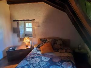 a bedroom with a bed with a lamp and a window at Maison de Vacances Chadirac in Auriac