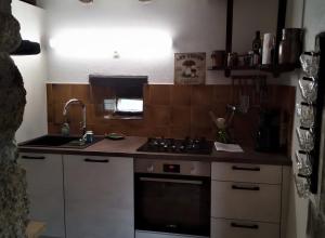 a small kitchen with a stove and a sink at Maison de Vacances Chadirac in Auriac