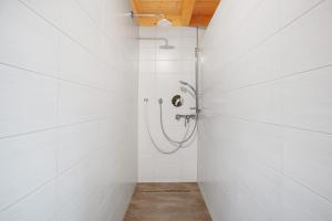 a bathroom with a shower with white tiles at Ferienwohnung Blösling 2 in Bernau im Schwarzwald +36 photos
