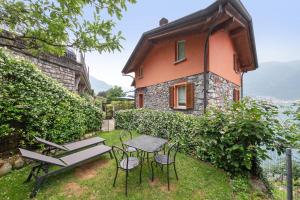 a small house with a table and chairs in front of it at Luxury Lakefront Maisonette in Lezzeno