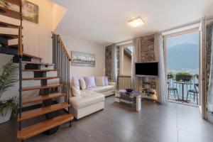 a living room with a couch and a tv at Luxury Lakefront Maisonette in Lezzeno