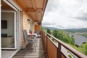 a balcony of a house with a table and chairs at Ferienwohnung Blösling 2 in Bernau im Schwarzwald