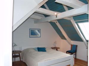 a bedroom with a white bed and two chairs at Fachwerkhaus Korntenne in Eimelrod