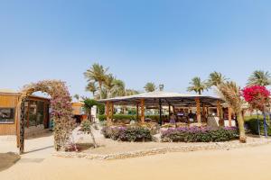 a pavilion with flowers and plants in front of a building at Blend Elphistone Resort Marsa Alam in Abu Dabbab