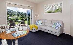 a living room with a couch and a table at Flaxmill Cove B&B in Whitianga