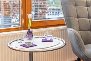 a table with a vase and two glasses on it at room4you in Hemmingen