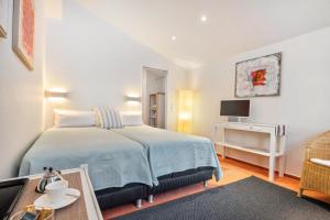a bedroom with a bed and a table and a tv at room4you in Hemmingen